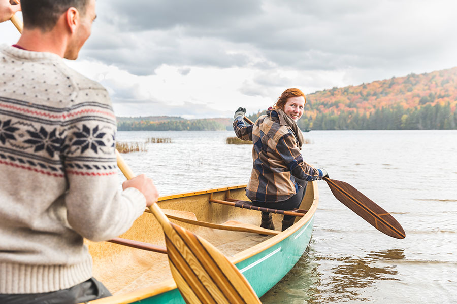 About Our Brokerage - Happy Couple Canoeing on a River in the Fall
